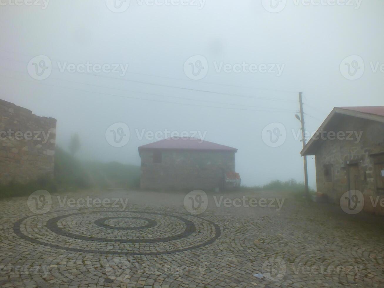 Old stone houses in Dumanli Village in foggy weather, Gumushane, Turkiye. Santa Ruins. photo