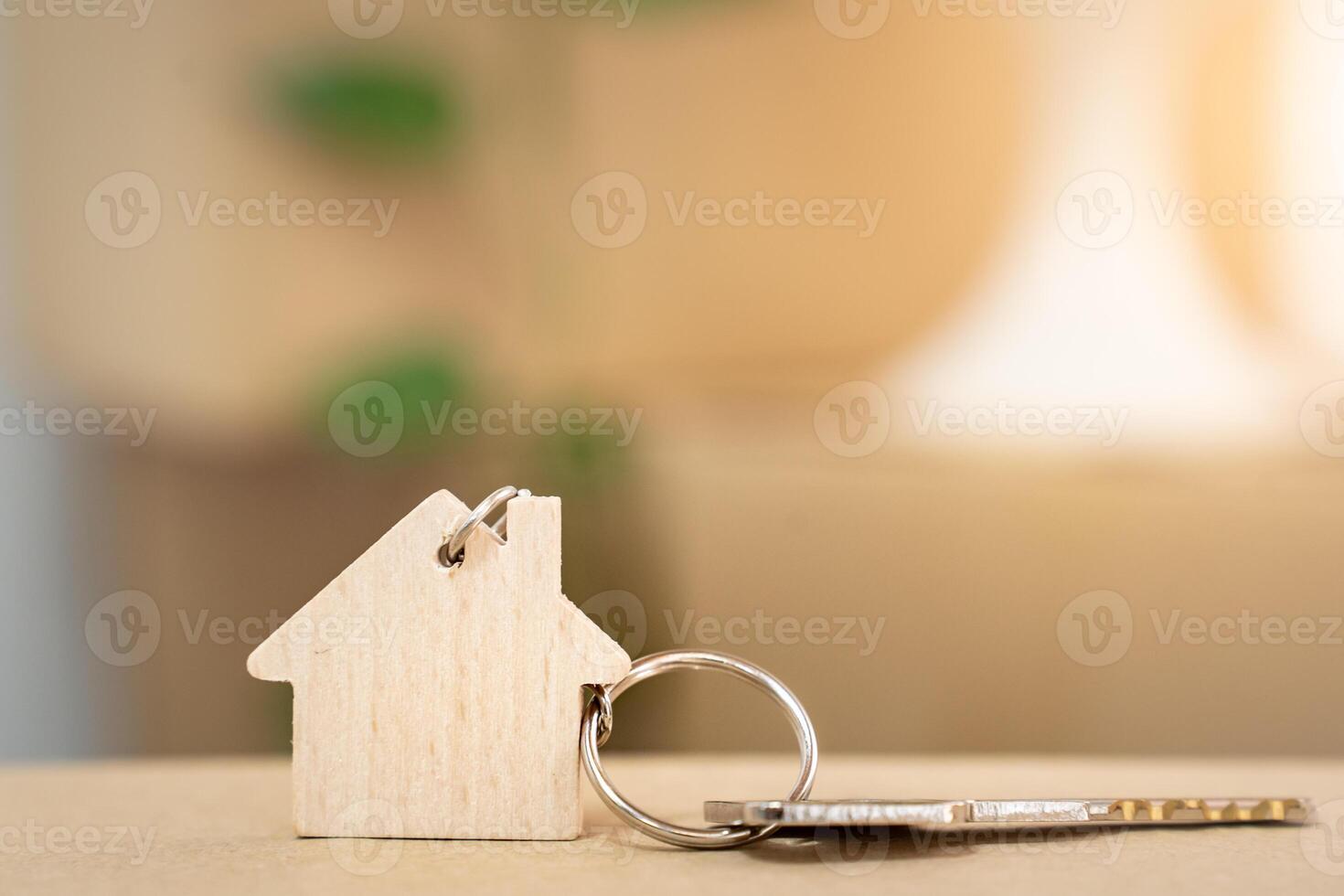 House keys on keyring in the shape of a wooden house with copy-space for text photo