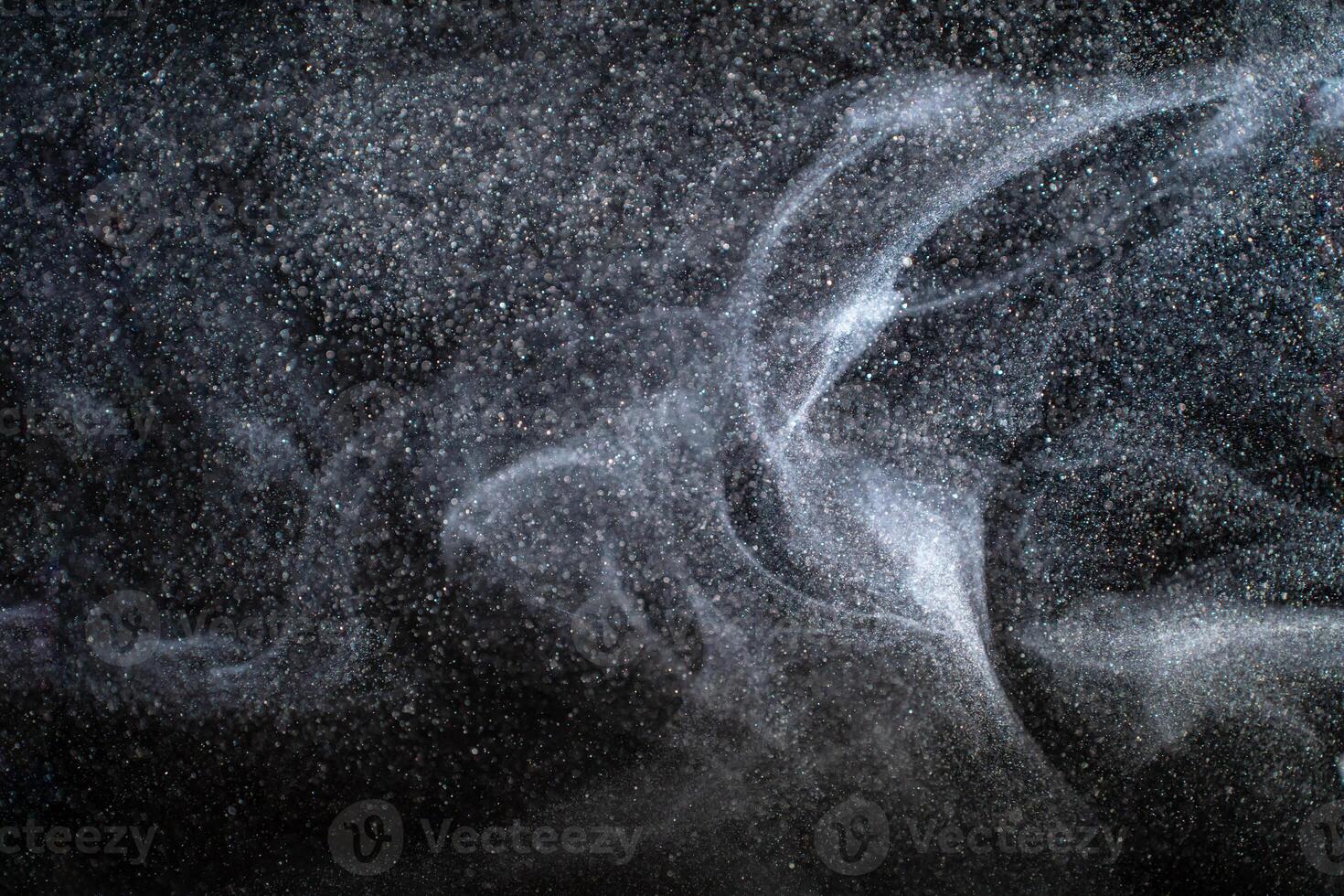 Dust particles cloud generating abstract shapes with black background and copy space for text. photo
