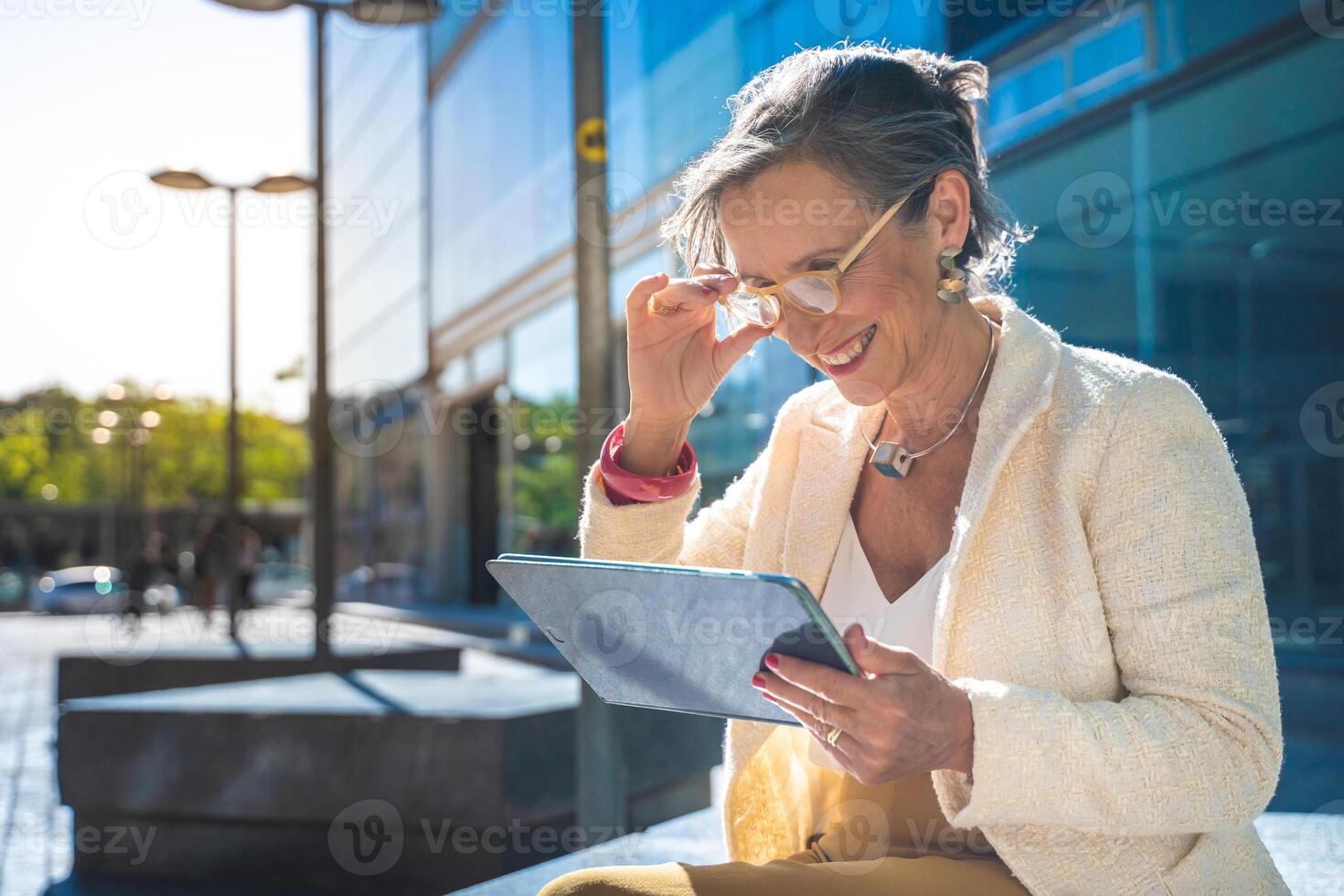 Senior business woman with technology happy working with a tablet in a modern city. photo