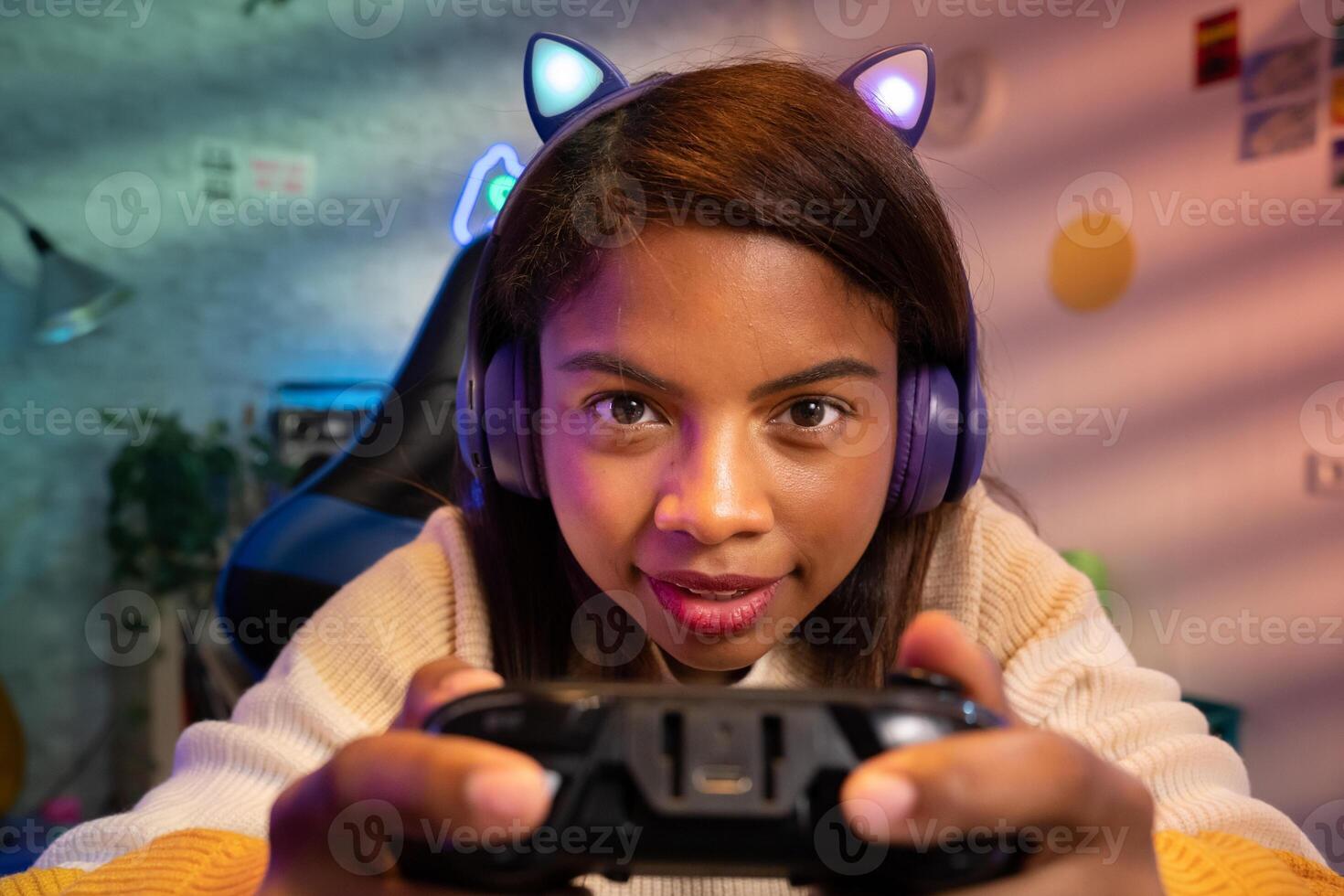 Happy latin female gamer playing game streaming online with microphone and headphones photo