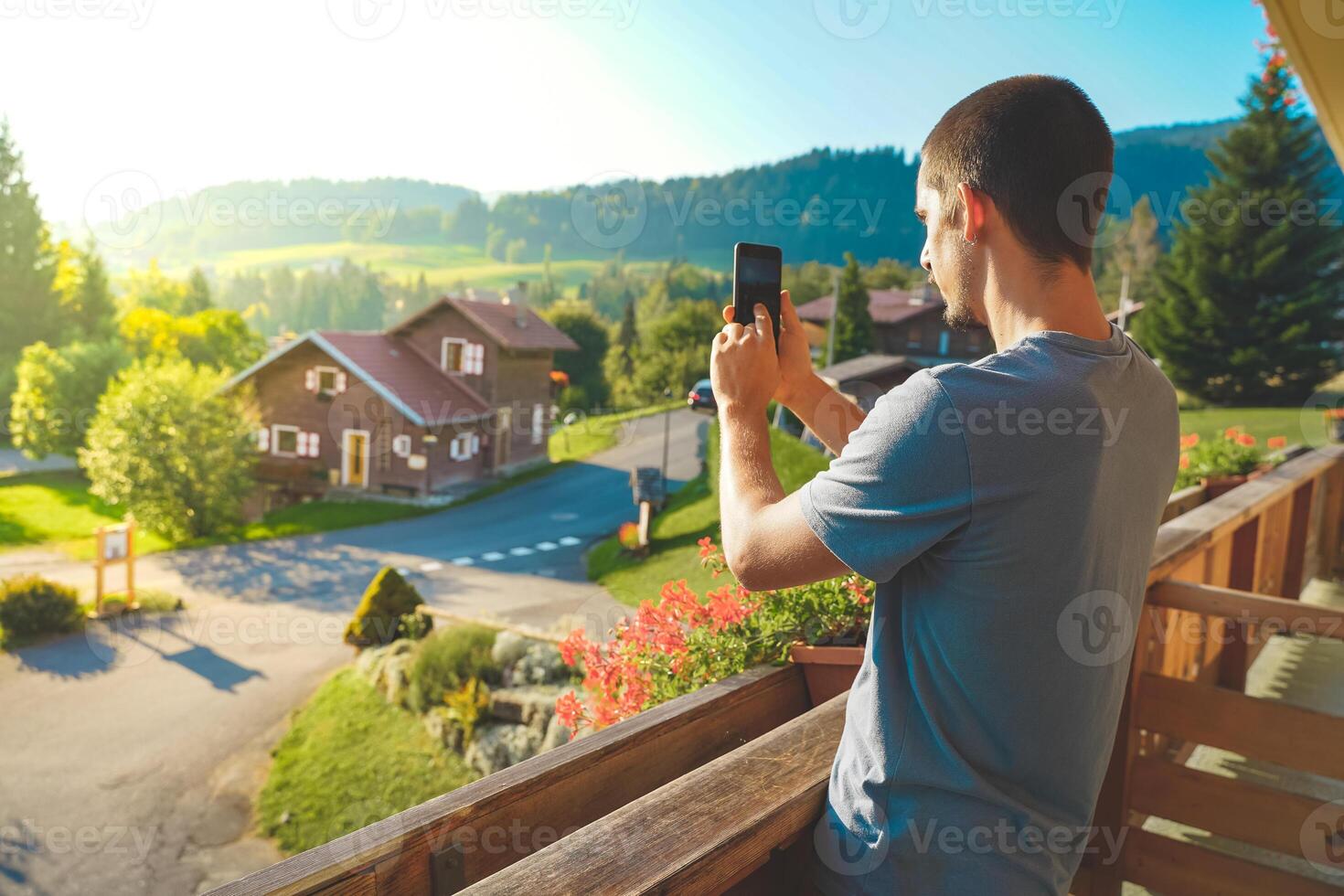 Young man taking a picture of a beautiful scenic mountain background. Attractive Traveler. photo