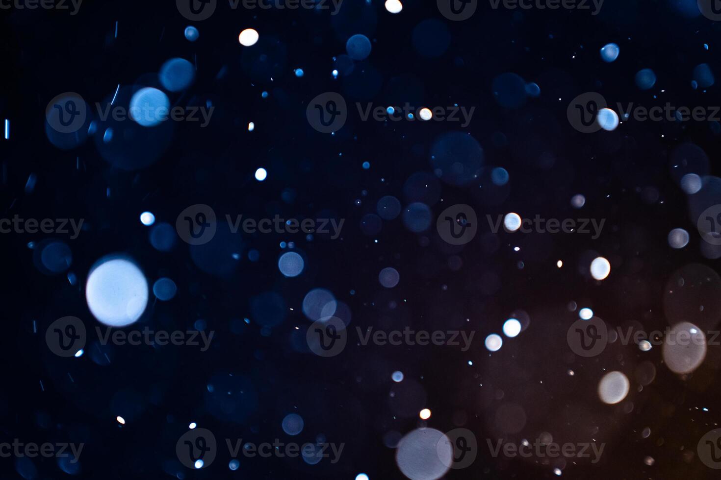 Closeup of dust particles on black background bokeh blur overlay effect with copy space for text. photo