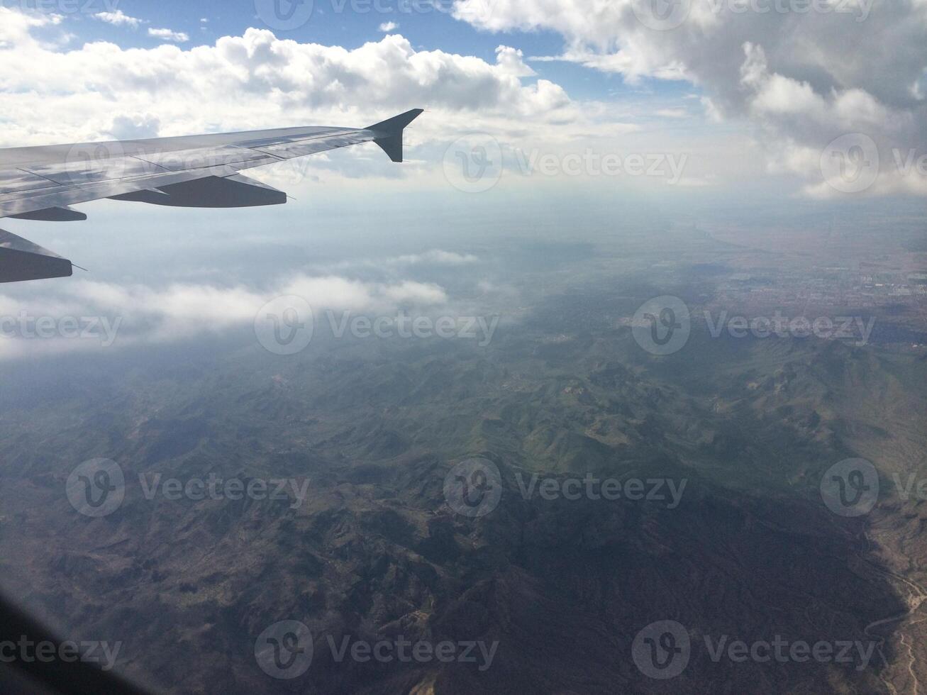 View from Airplane Window of Mountains and Clouds photo