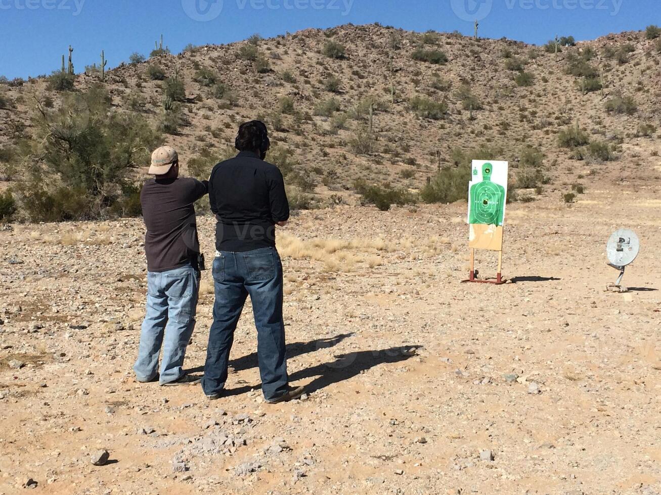Anonymous Men Practicing Target Shooting in the Desert photo