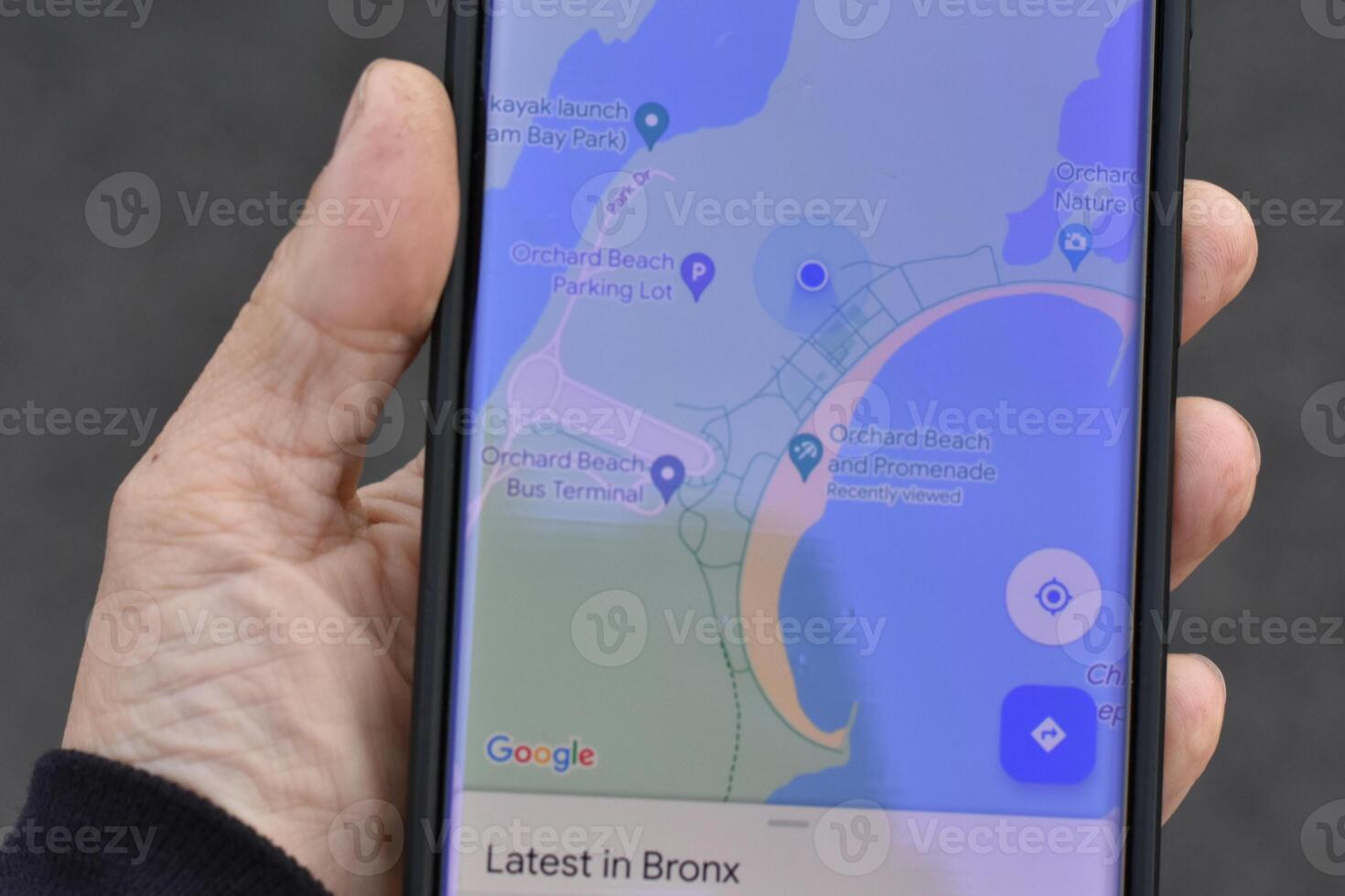 Hand Holding Phone with Map of Orchard Beach, Bronx, New York City photo