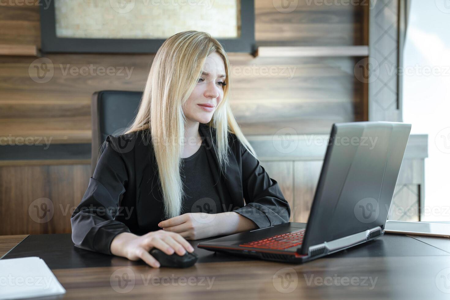 Young female teacher is sitting in front of laptop conducting lesson, concept of online teaching. photo