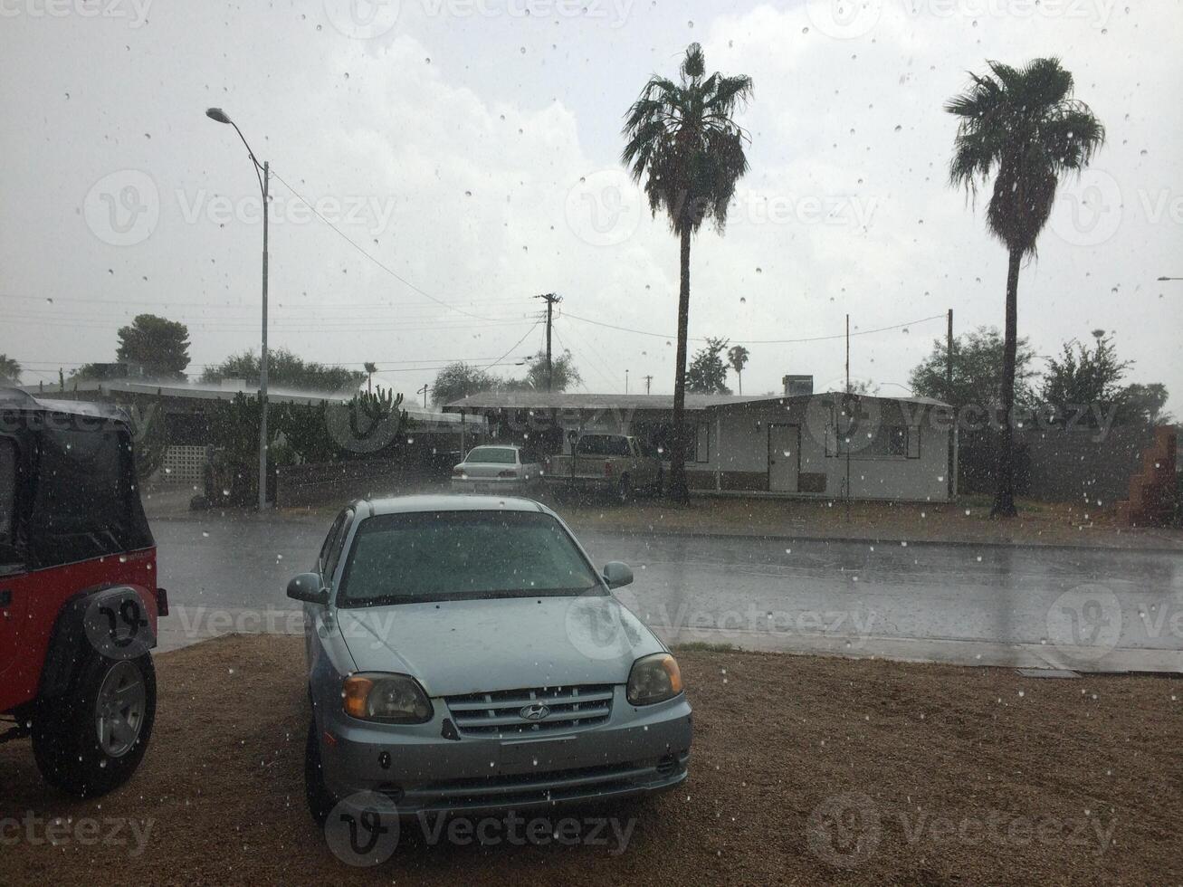 Car Parked in Front Yard During Afternoon Rain Storm in Arizona photo