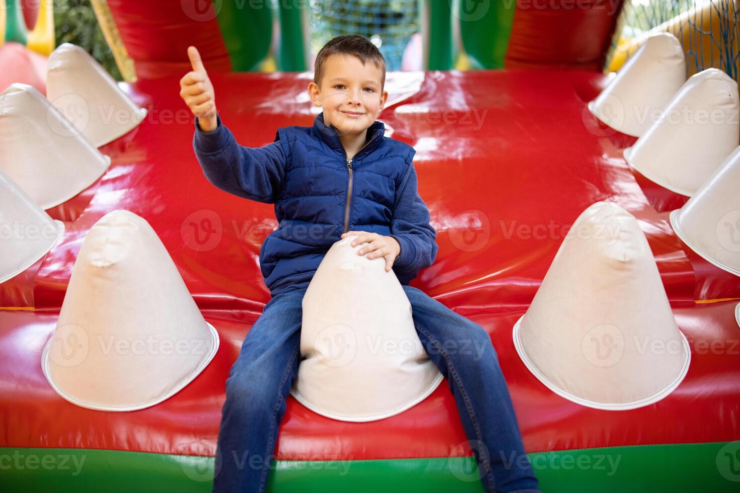 Happy boy having a lots of fun on a colorful inflate castle photo