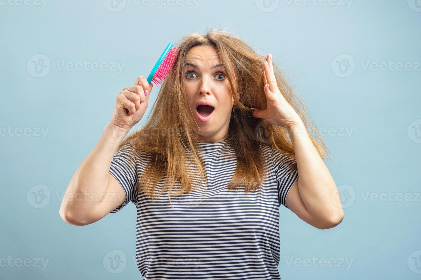 A young woman with comb is very upset about her hair problems photo
