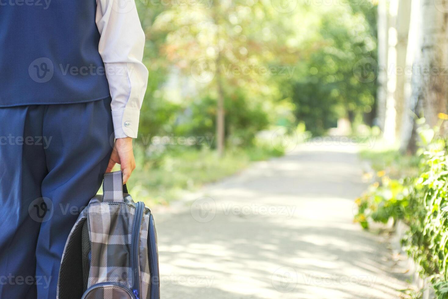 The child goes to school with backpack. Schoolboy goes to school in the morning photo