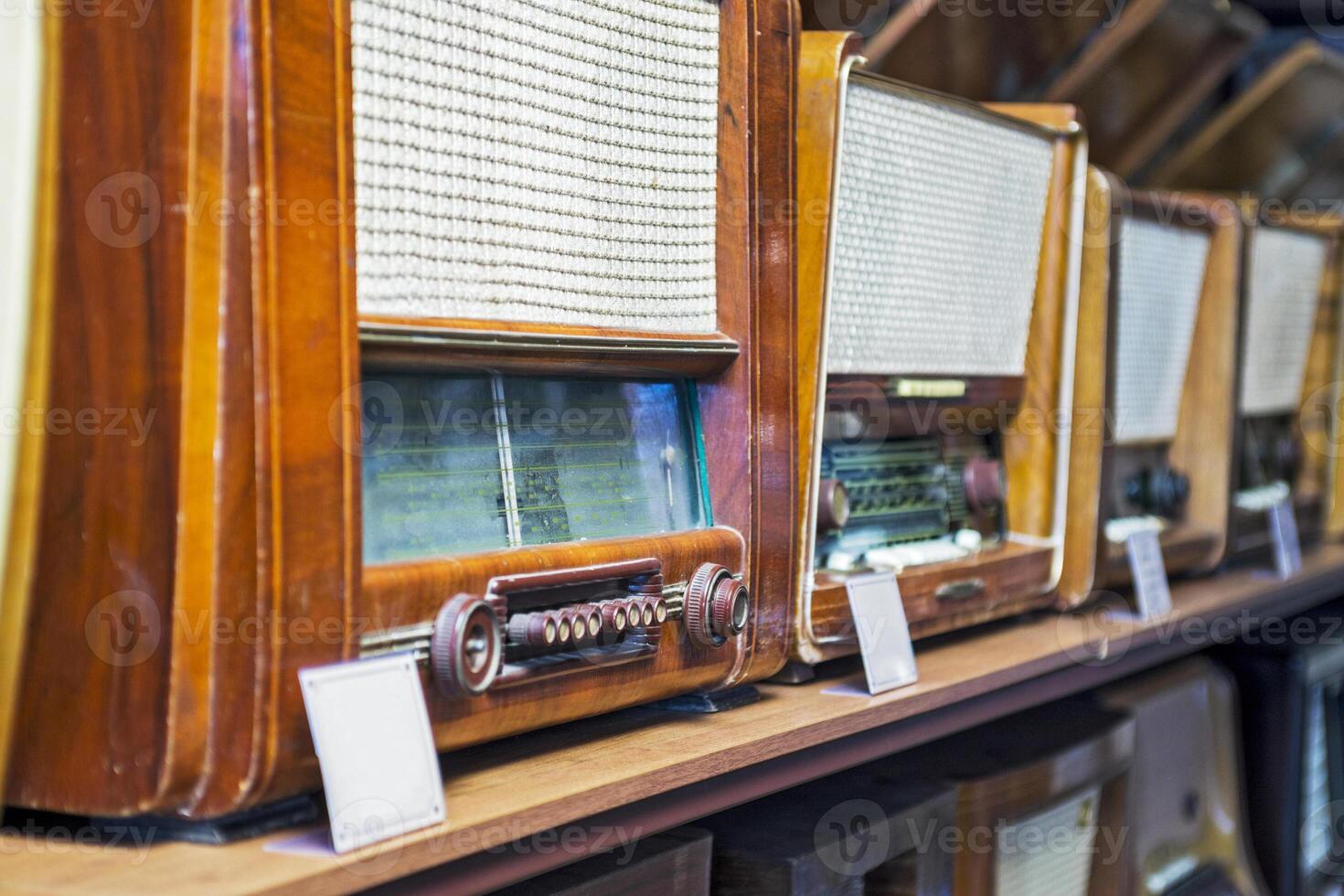 A lot of retro radios displayed over the shelves. photo