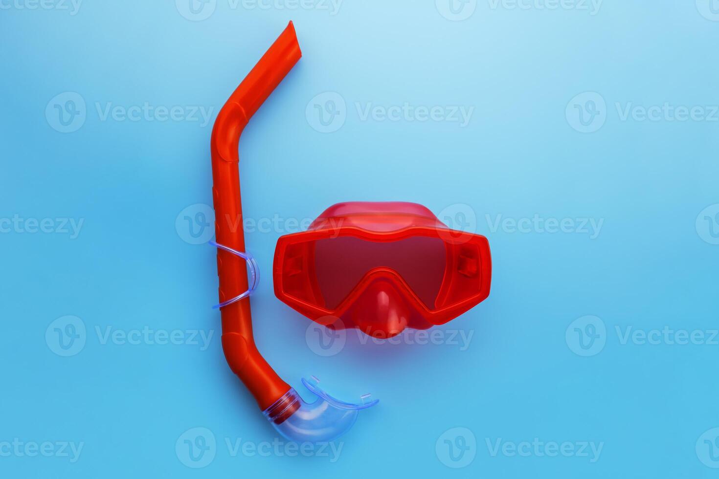 A set of red swimming mask and snorkel on a blue background photo