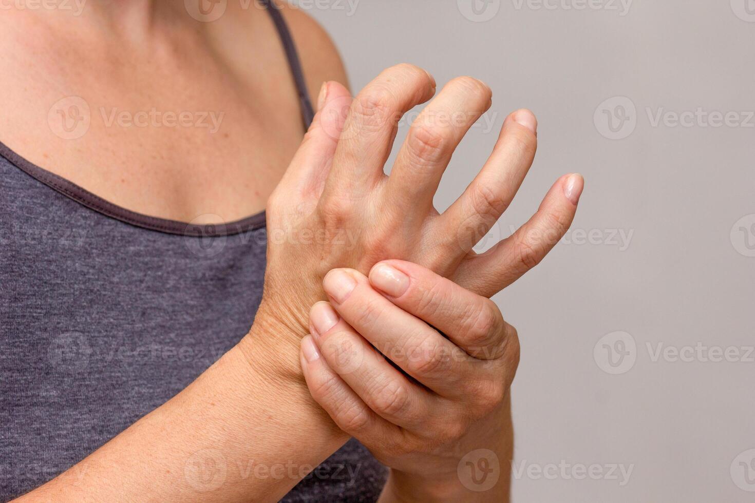Woman hands showing hand with arthritis over cropped body photo
