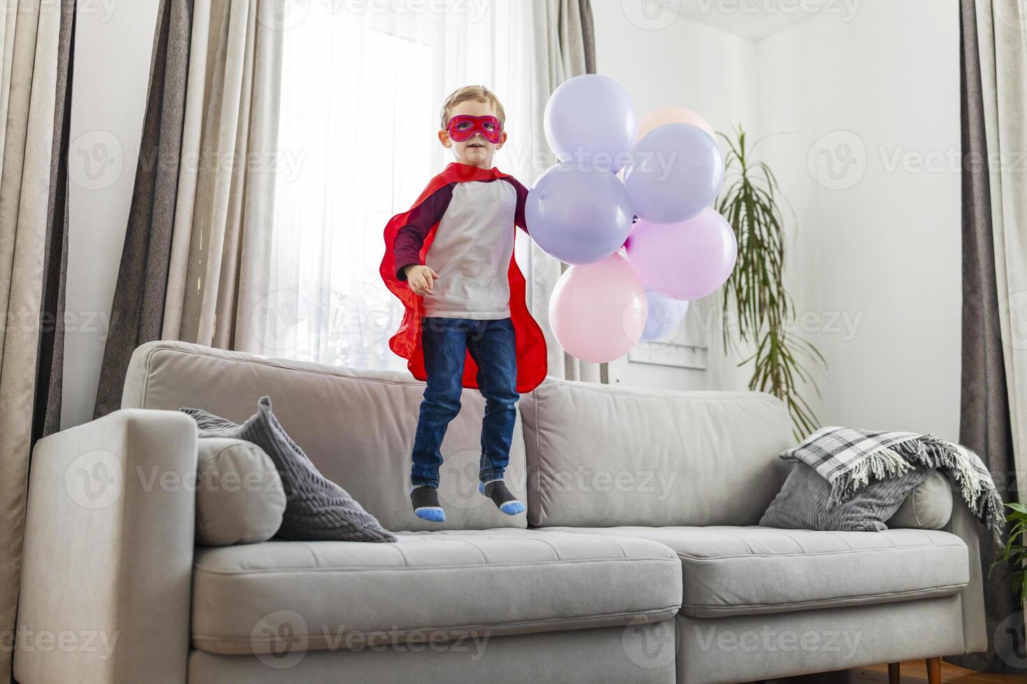 Child in superhero costume with balloons. photo