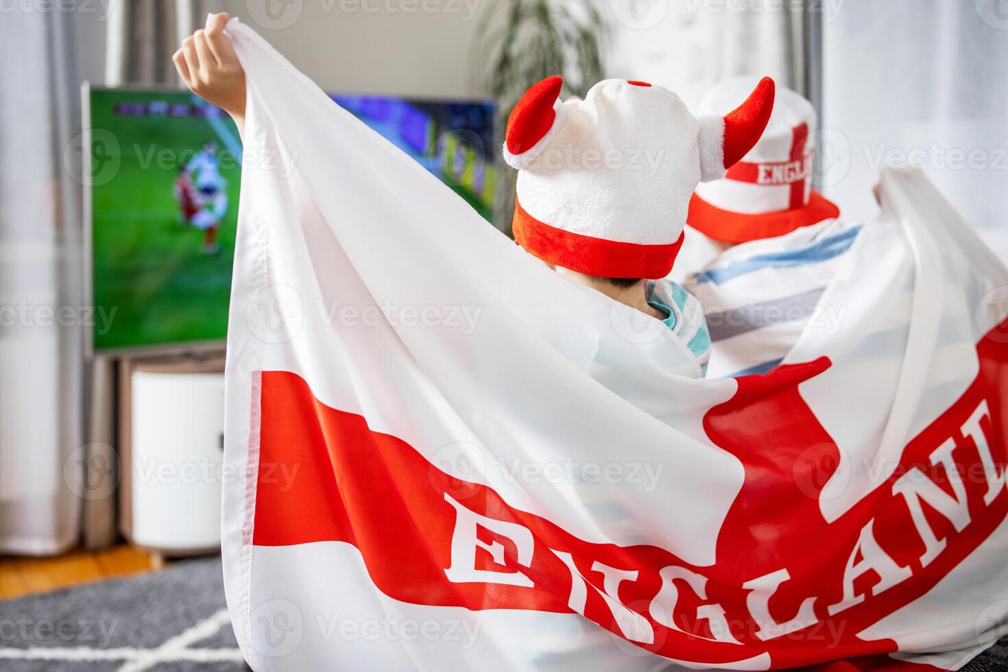 Father and son with England flag watching soccer game on TV photo