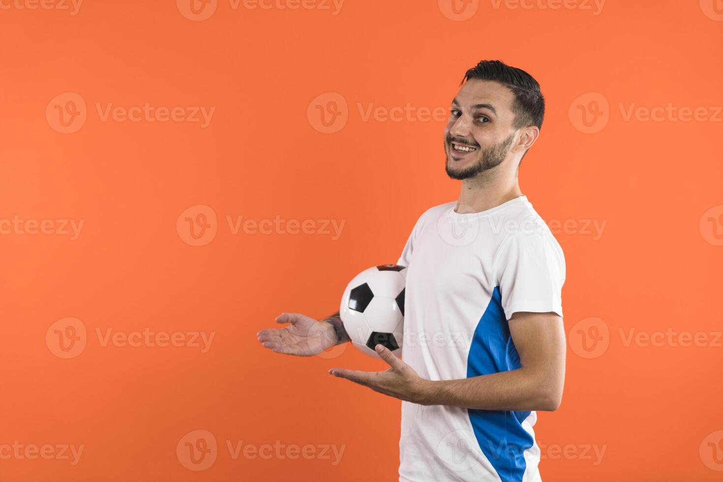 Happy smiling Football fan or player presenting a product on the left with open hands photo