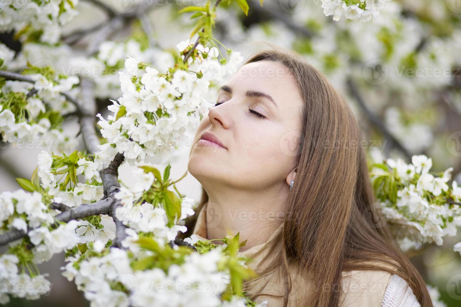 Woman Enjoying the Scent of Spring Blossoms photo