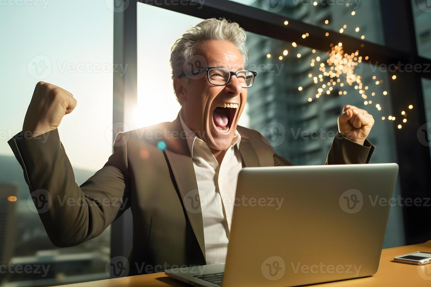 a man is sitting in front of a laptop computer with his fist in the air photo