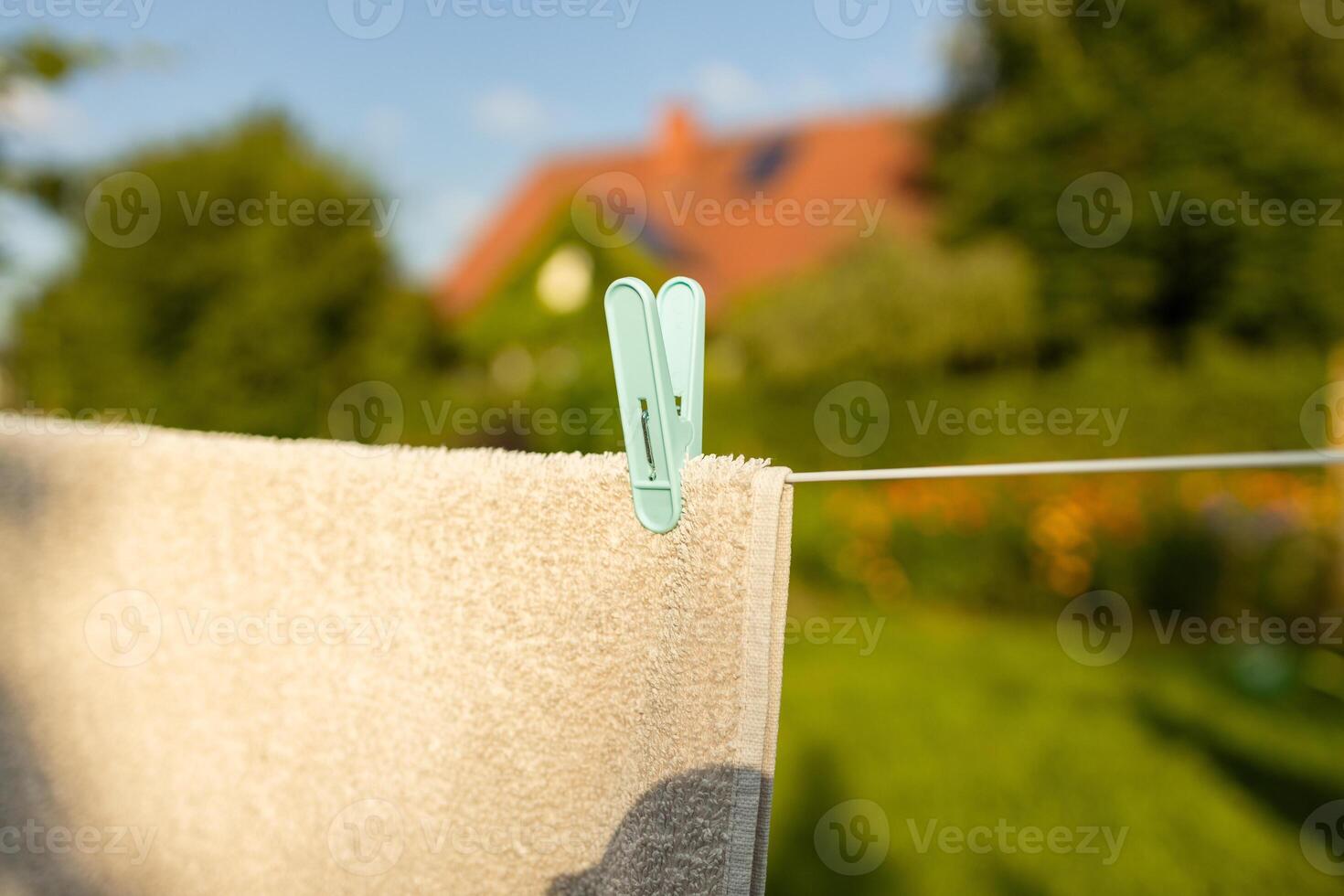 Recently washed clothes are hung along the line to dry with colorful plastic clothespins at lunchtime. Concept of everyday household items. photo