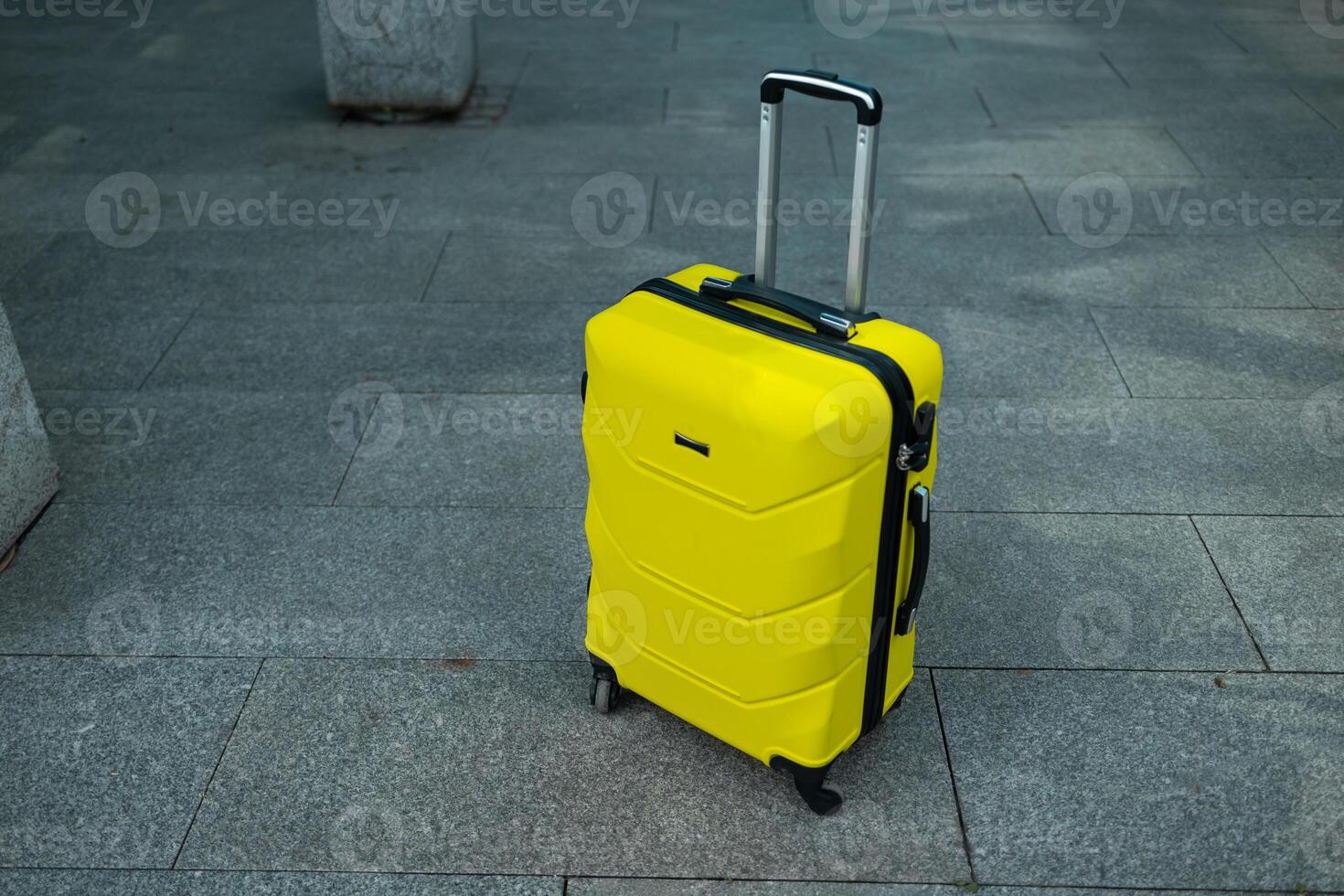 Stylish suitcase standing in empty airport hall, unrecognizable traveller's luggage waiting in terminal. photo