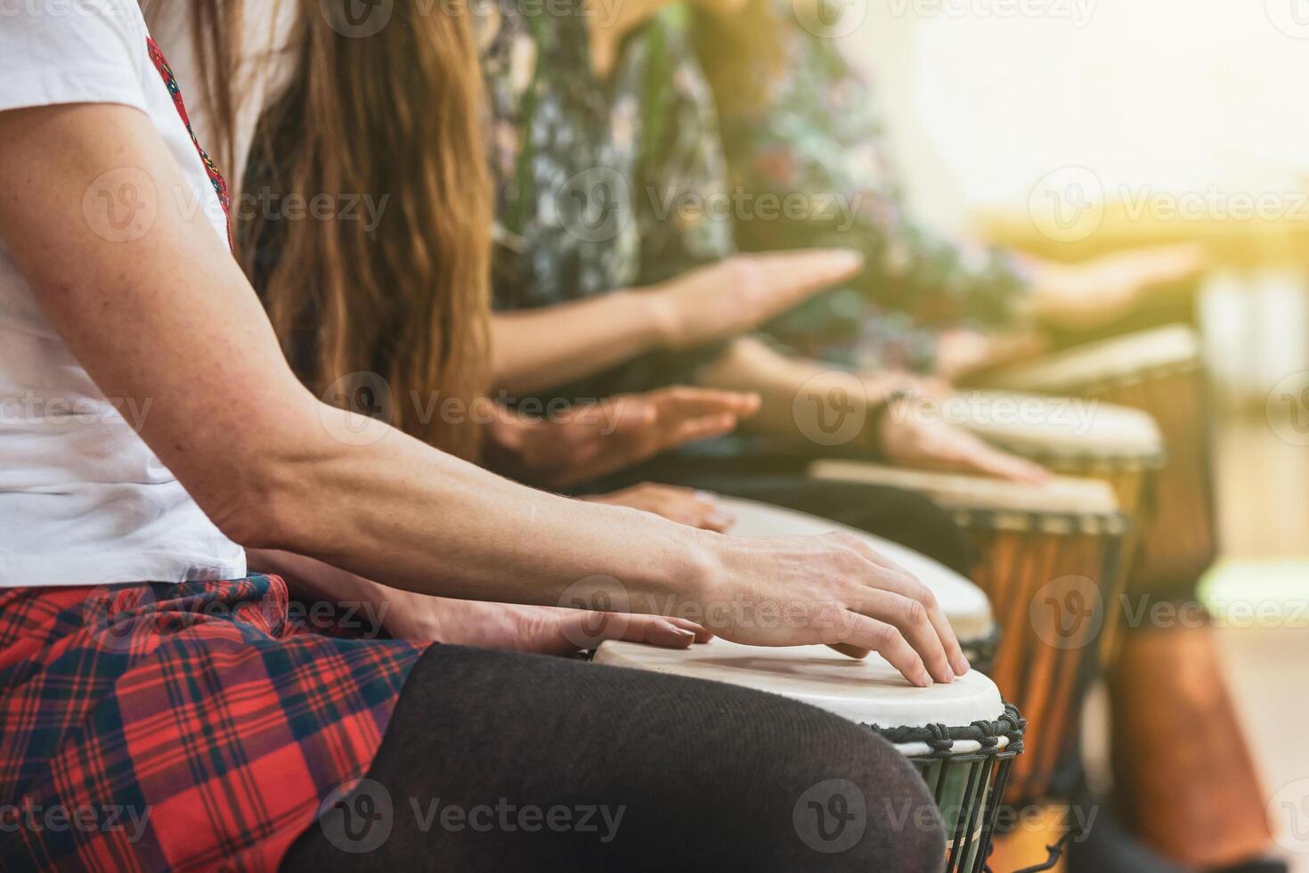 Group of people playing drums during a music therapy lessons, jembe drum, drumming concept photo