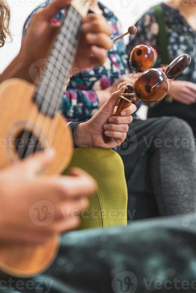 Group of people playing on different kinds of musical instruments during music therapy photo