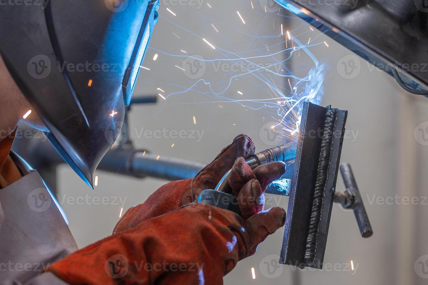 Welder man welding a metal, using a blowtorch, electric arc, or other means, and uniting them by pressing, heavy industrial concept photo