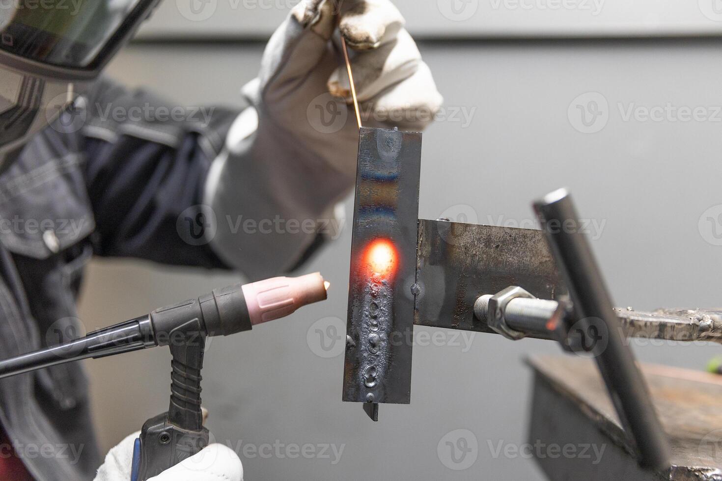 Welder man welding a metal, using a blowtorch, electric arc, or other means, and uniting them by pressing, heavy industrial concept photo