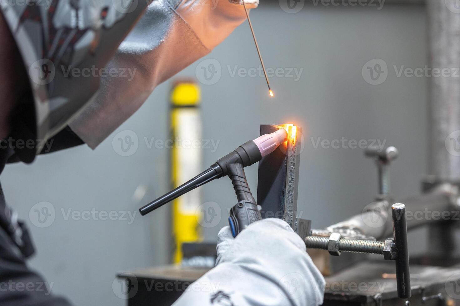 Welder man welding a metal, using a blowtorch, electric arc, or other means, and uniting them by pressing, heavy industrial concept photo