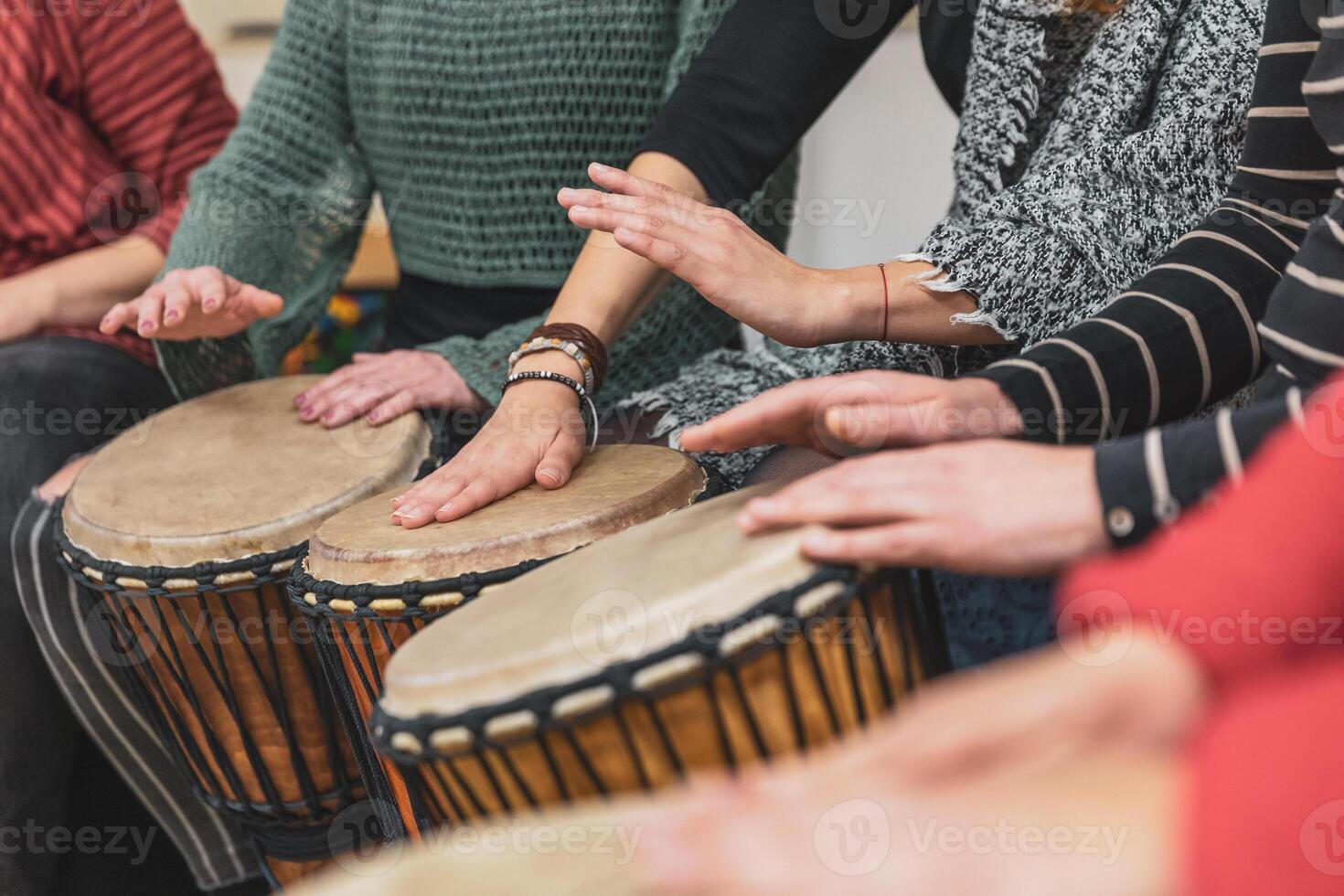 Group of people playing drums during a music therapy lessons, jembe drum, drumming concept photo