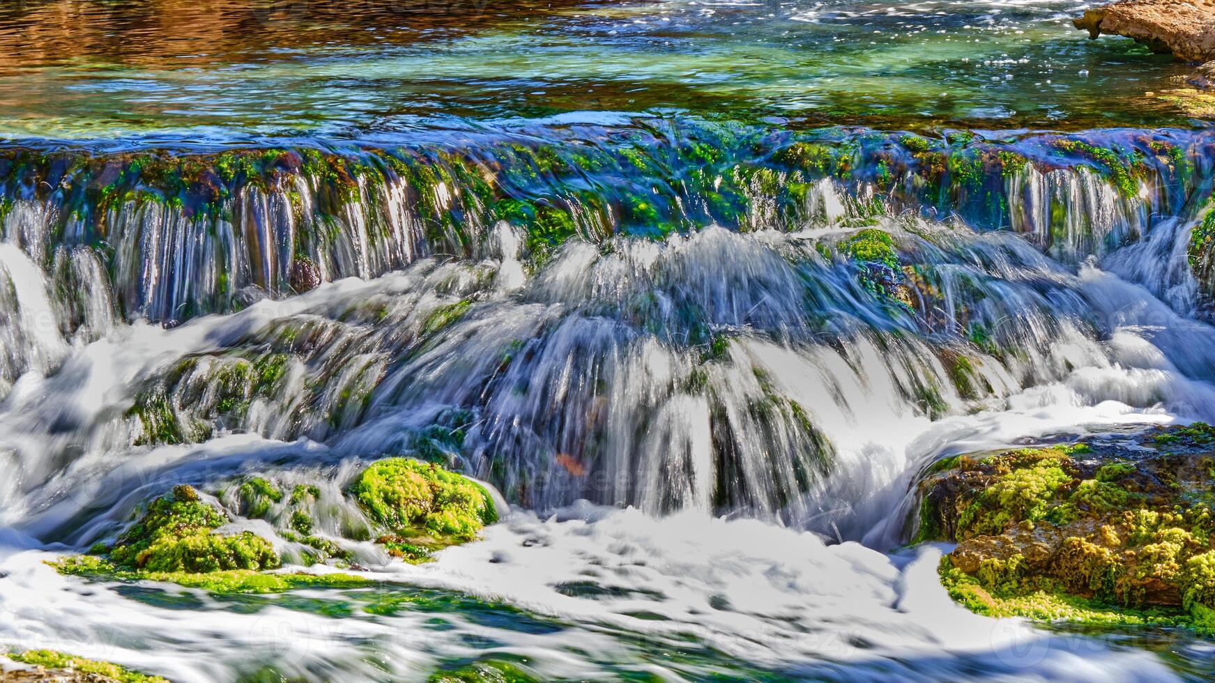 Waterfall at slow shutter speed in morning sunlight photo