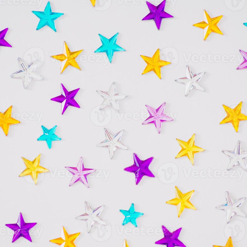 Colorful glitter stars on white background. Festive holiday pattern backdrop. Trendy celebration image background. Flat lay, top of view. photo