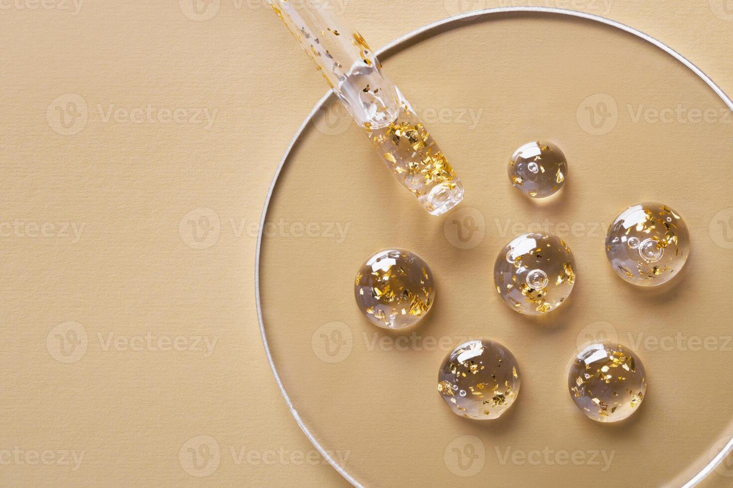 Samples of gel cosmetic products with gold in a Petri dish on beige background photo