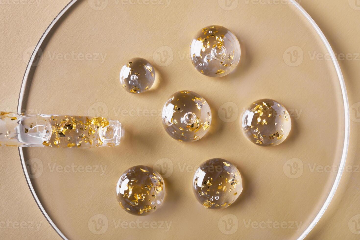 Samples of gel cosmetic products with gold in a Petri dish on beige background photo