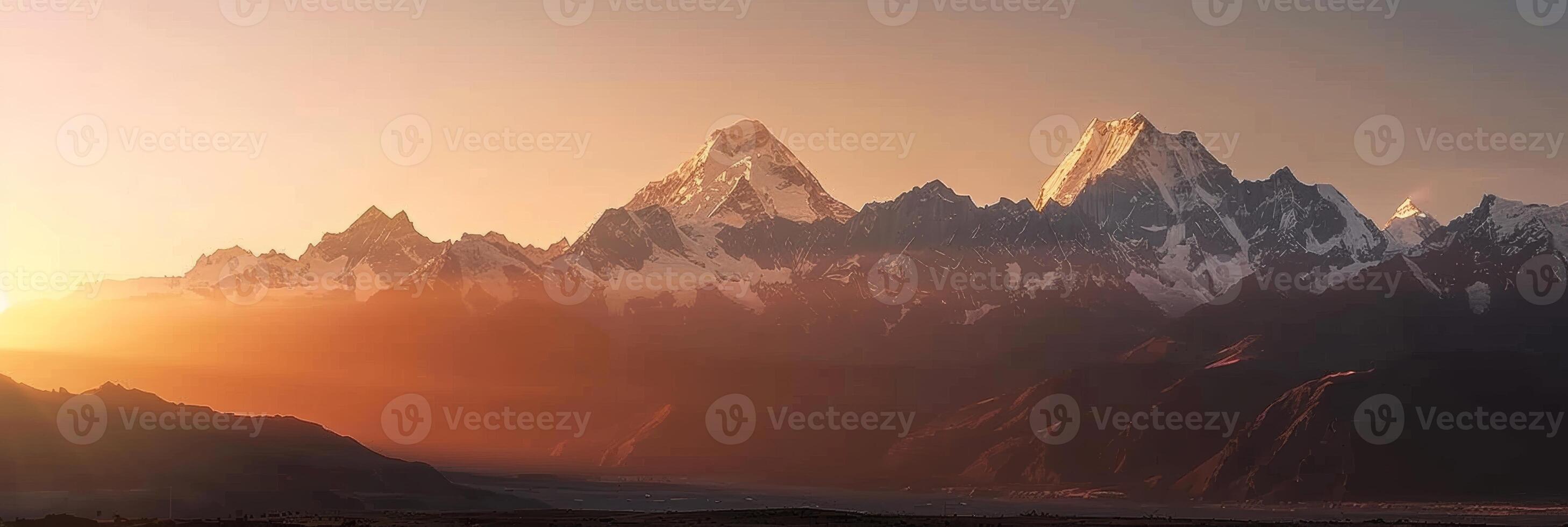 Last light of day casts a soft glow on snow-capped mountains. photo