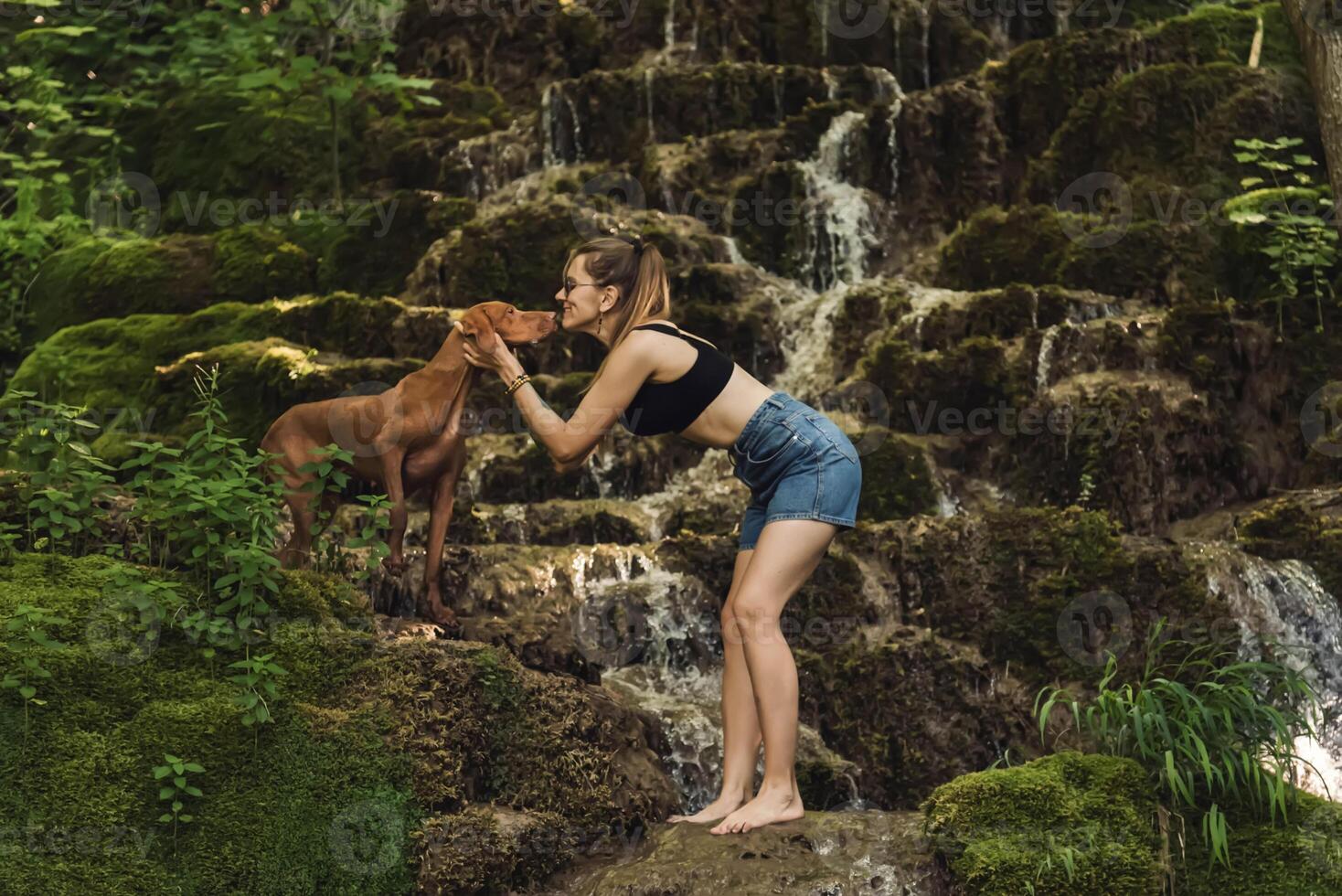 Woman with Dog in Nature by Mountain River Waterfall photo
