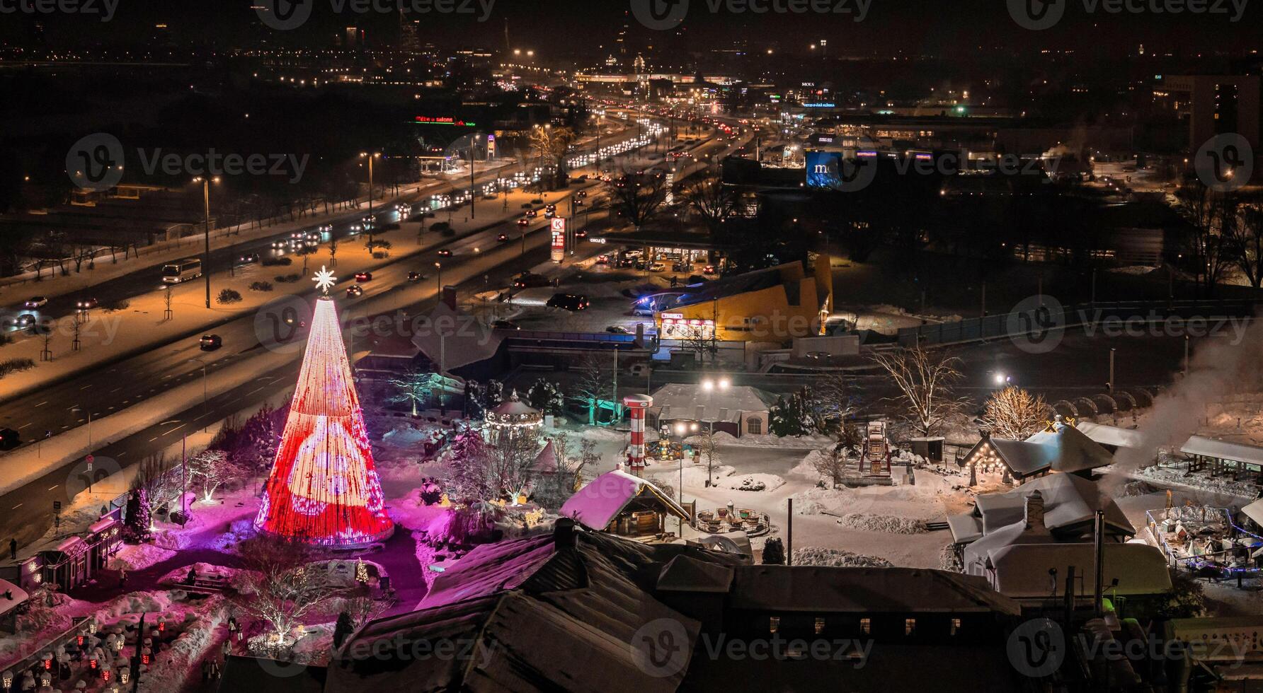 The most beautiful Christmas tree in Europe located in Riga, Latvia, at the Lido restaurant facility. Beautiful night view of the Christmas tree and people celebrating Christmas ice skating. photo