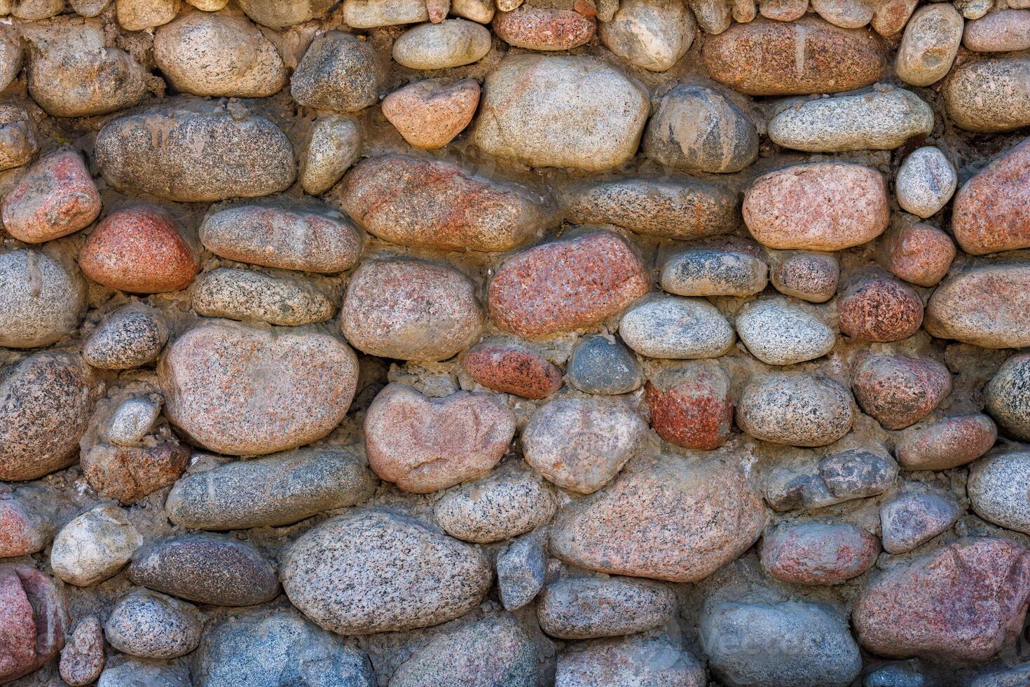 wall made of many colorful round stones, full-frame background and texture photo