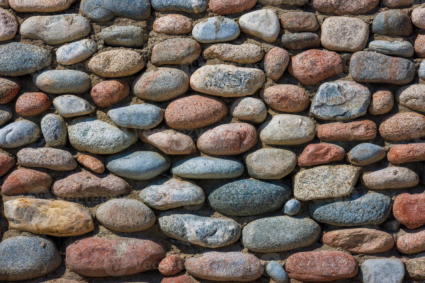 wall made of many colorful round stones, full-frame background and texture photo