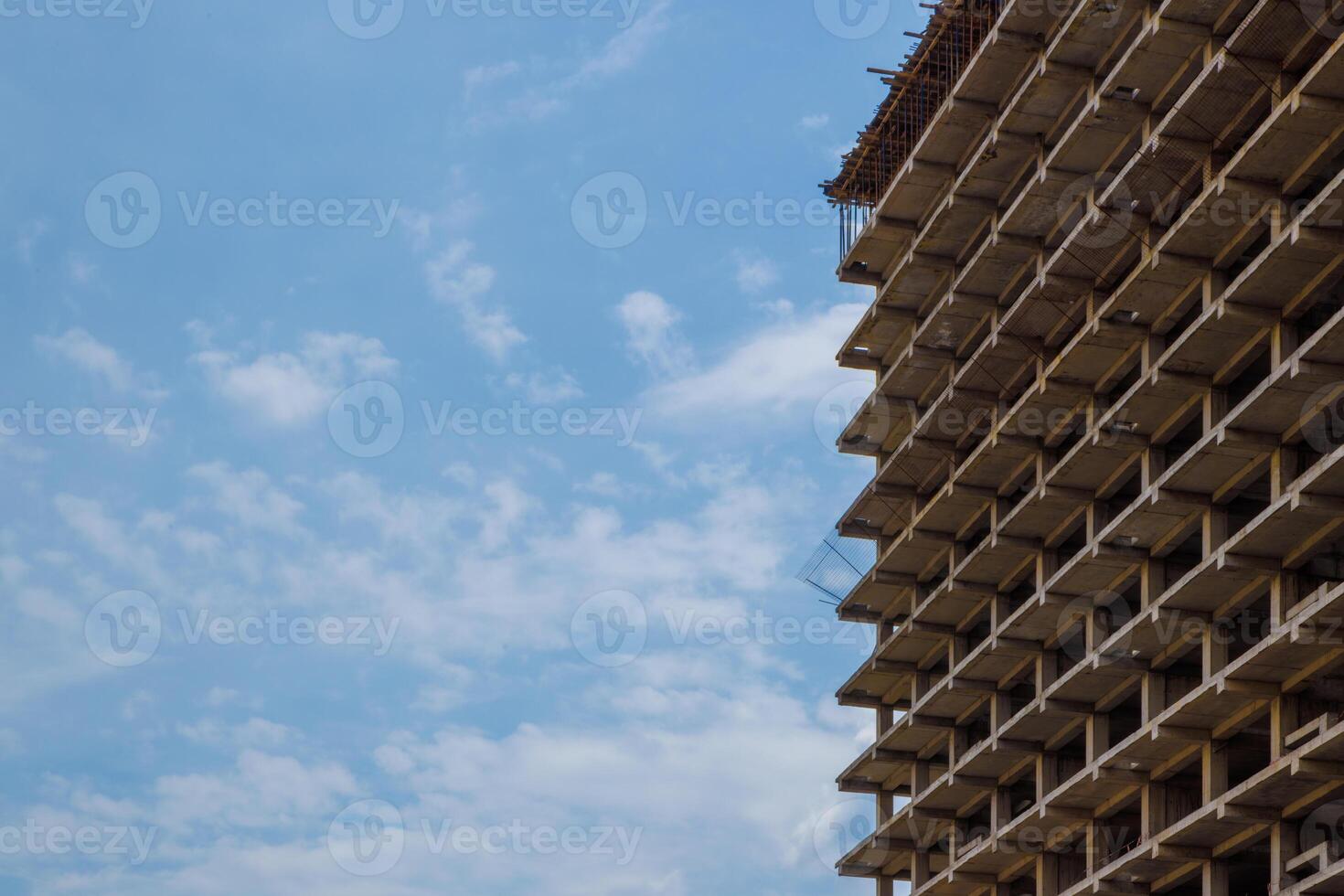 High-rise apartment building under construction against a blue sky with simple urban design photo