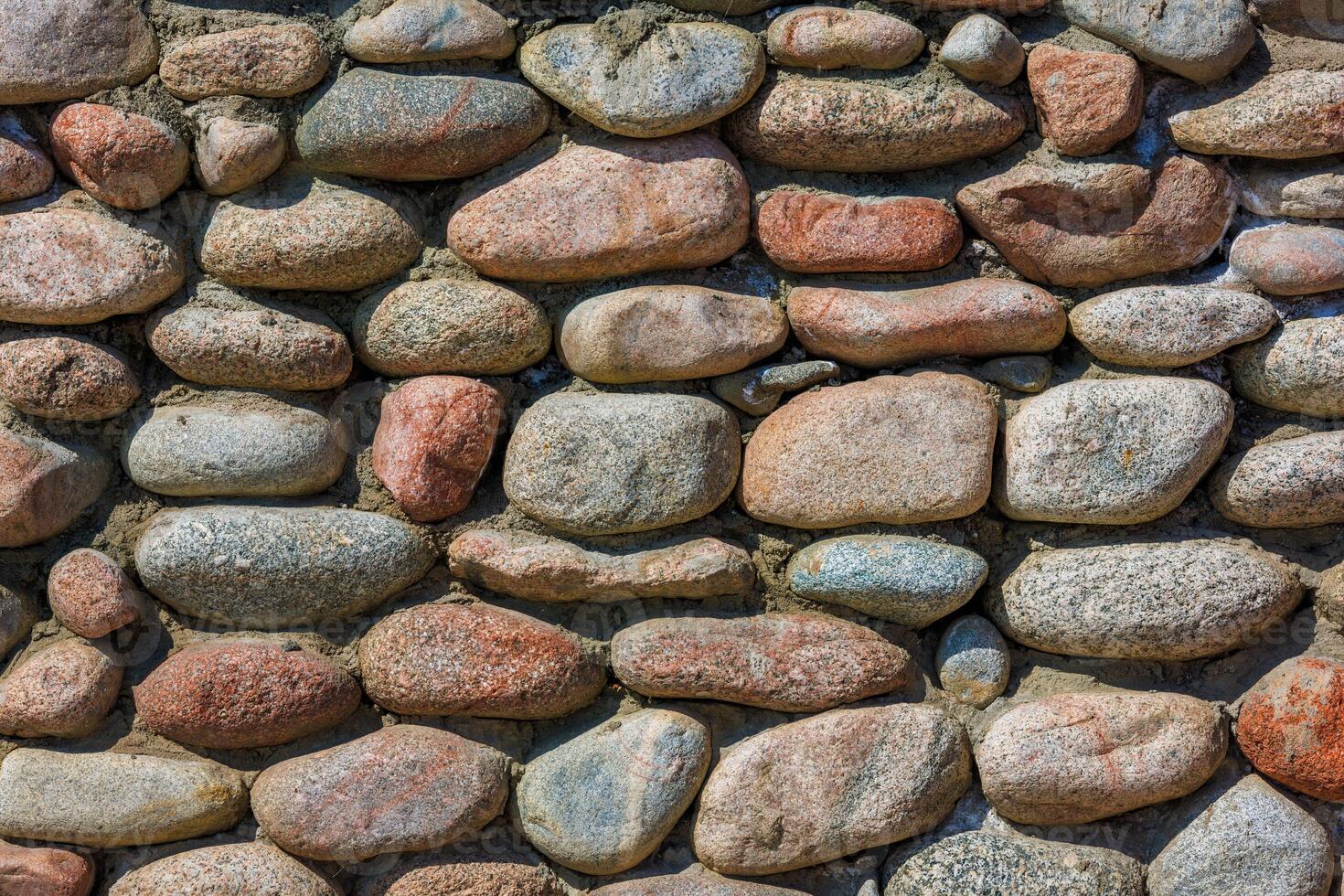 wall made of many colorful round stones, full-frame background and texture photo