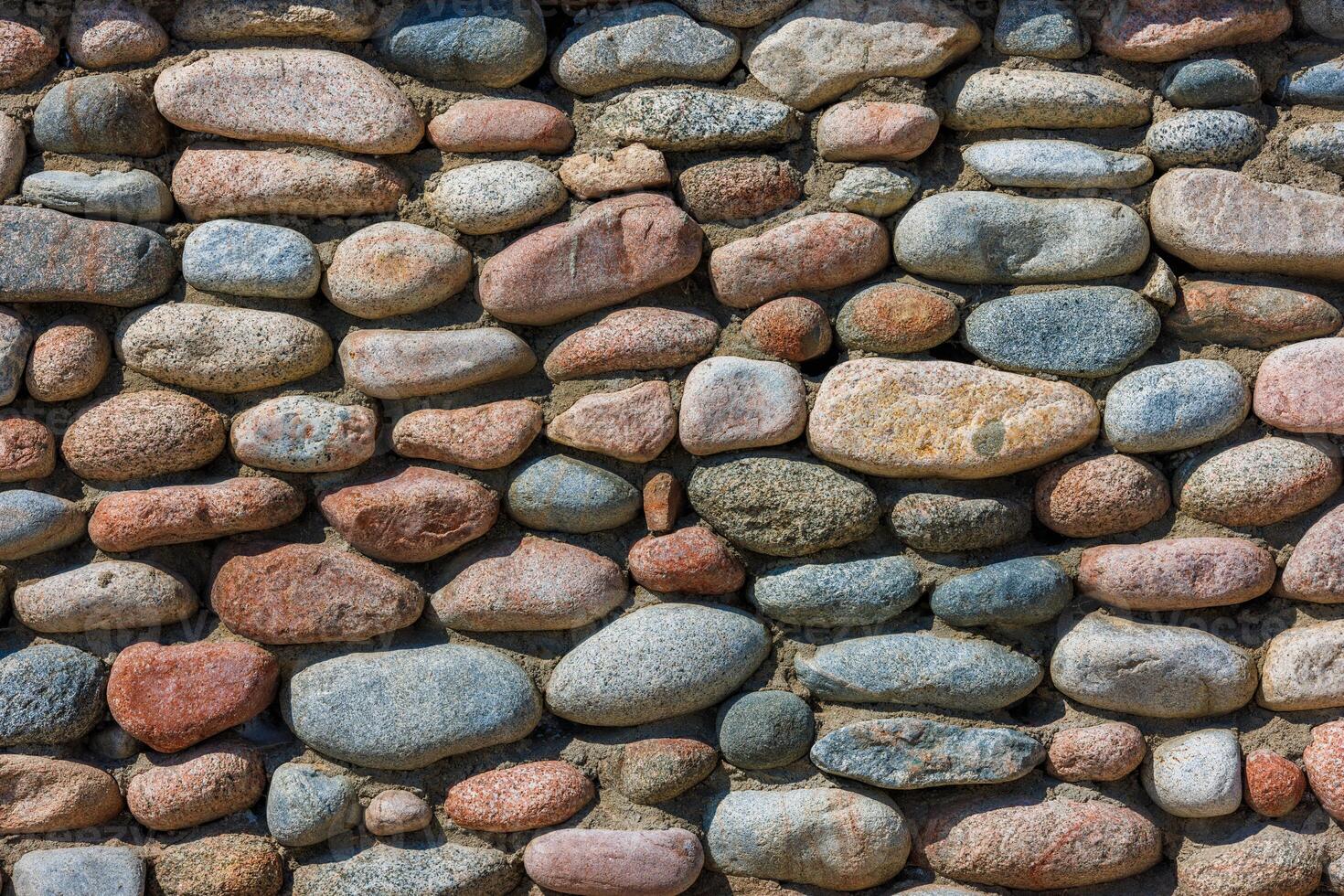 wall made of many colorful round stones, full-frame background and texture photo