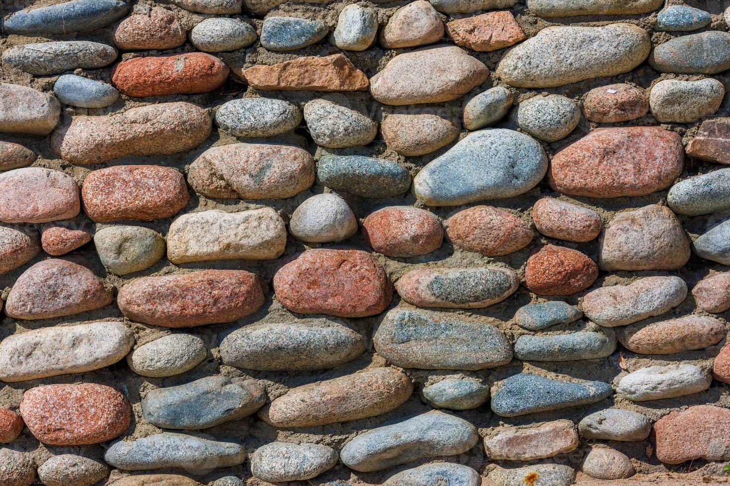 wall made of many colorful round stones, full-frame background and texture photo