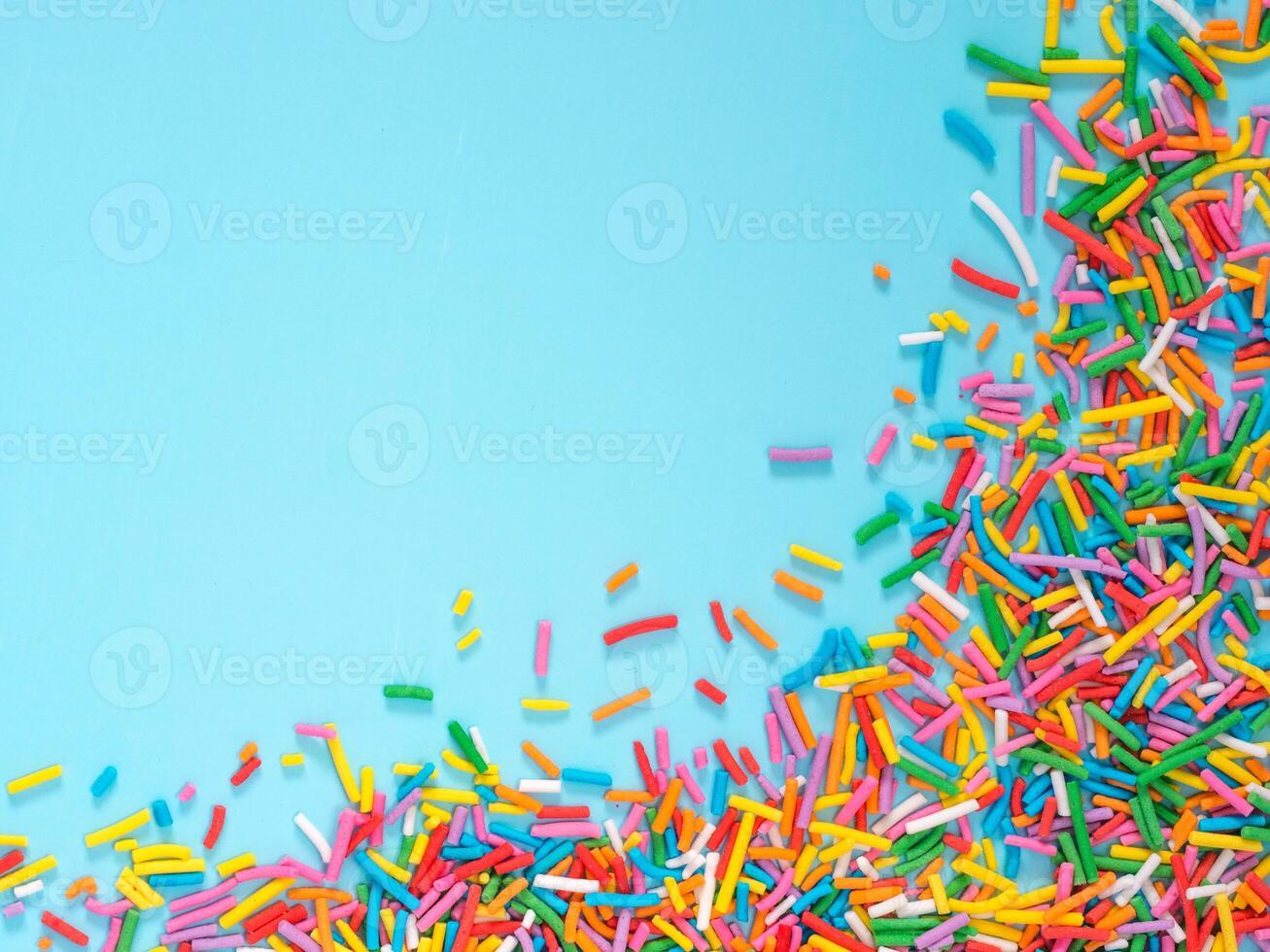 Border frame of colorful sprinkles on blue background photo