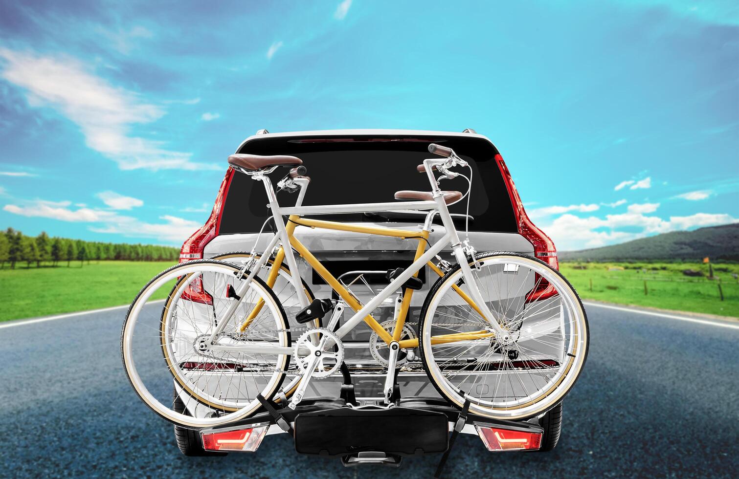 Back view gray suv car and bicycle on the rear rack with highway road view background photo