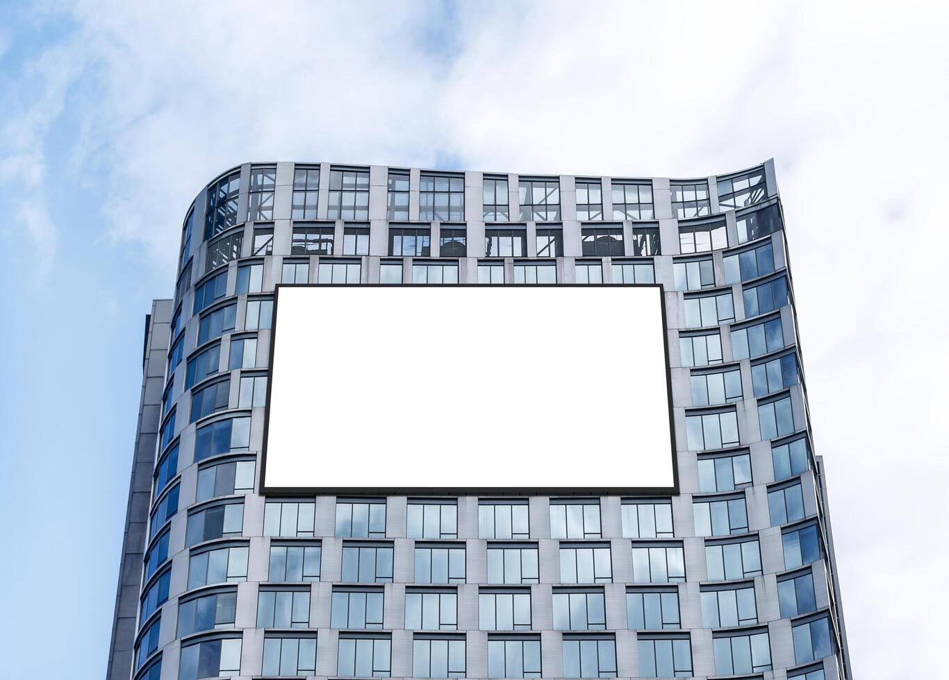 Mock up white horizontal large LED display billboard on tower building with blue sky background .clipping path for mockup photo