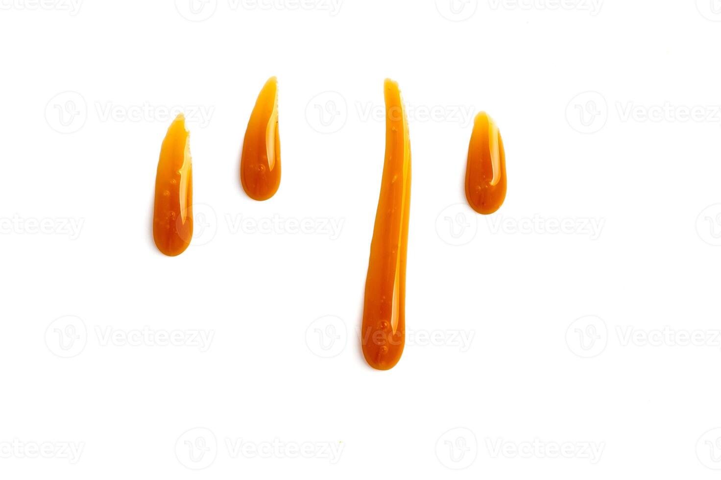 sweet caramel sauce drops isolated on white photo