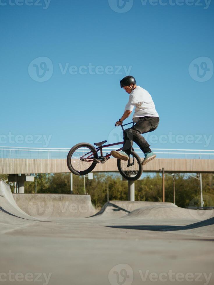 BMX bicycle rider making trick Bunny Hop Tailwhip Flat photo