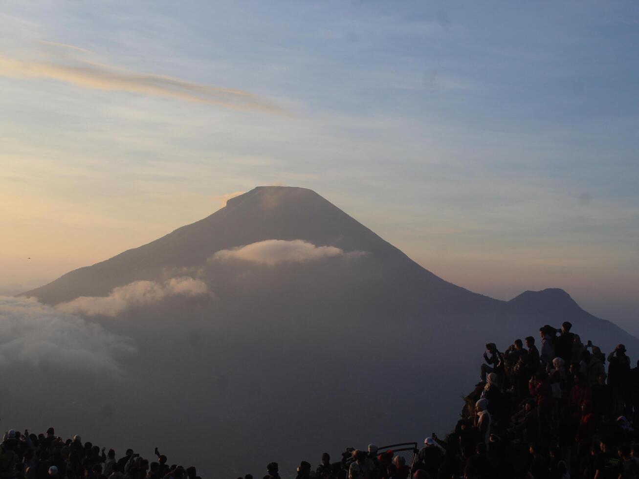 view of the sunrise on Mount Dieng with clouds covering the mountain photo